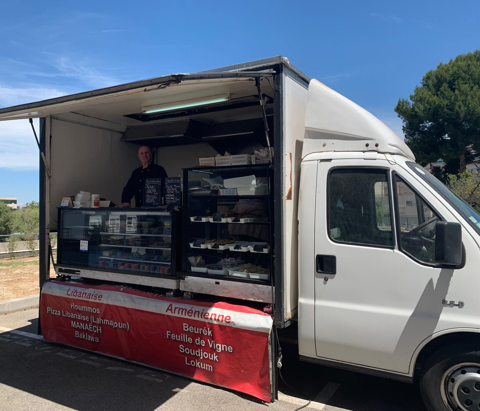 photo montrant le cuisinier et ses spécialités dans son food truck